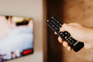 Widz korzystający z pilota podczas oglądania telewizji naziemnej w Polsce w 2025 roku