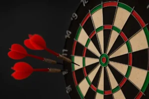 tarcza do darta z trzema rzutkami wbitymi w środek podczas Grand Slam of Darts 2025